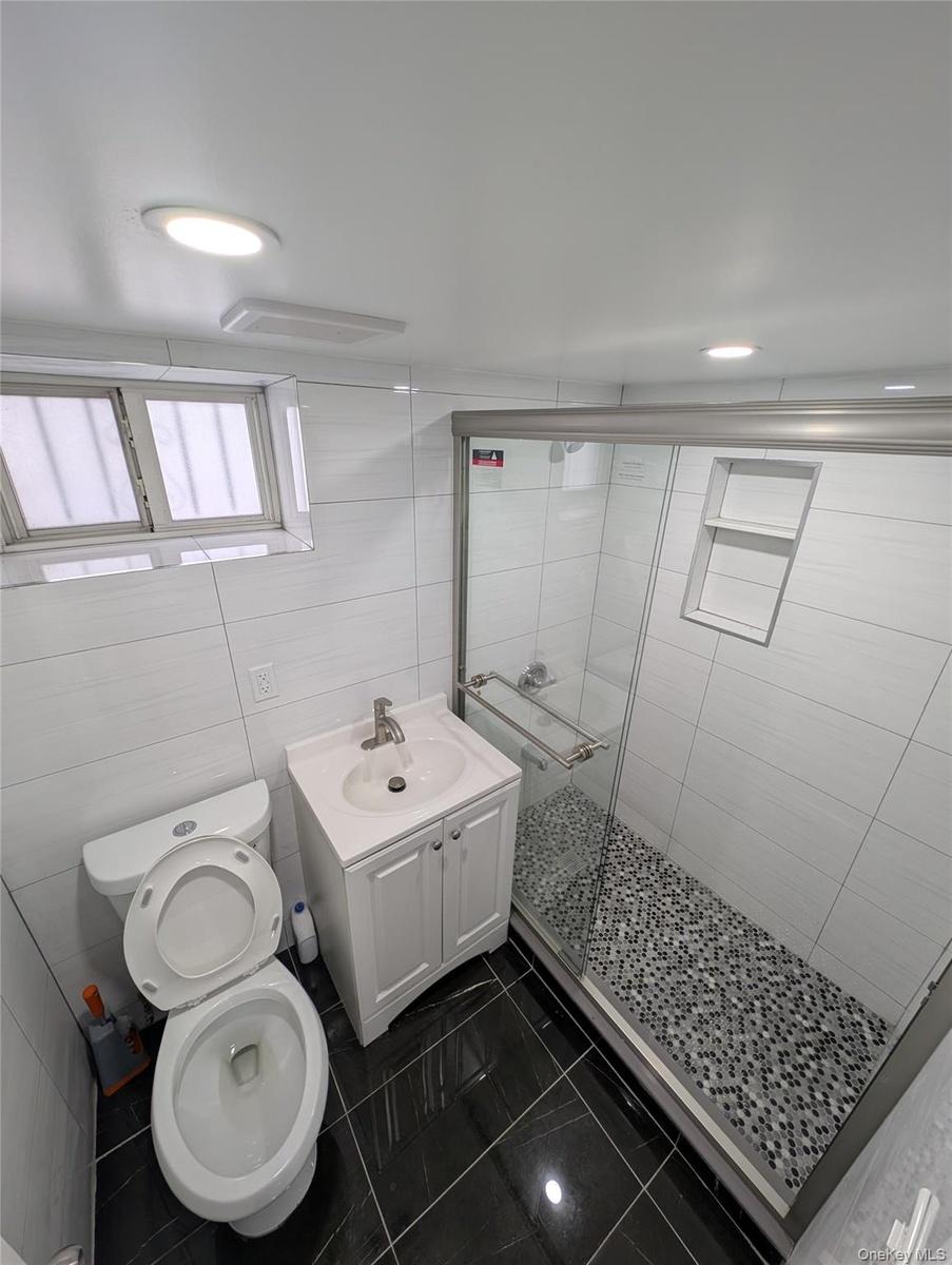 Bathroom featuring a shower stall, vanity, visible vents, toilet, and marble finish floor