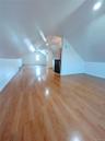 Additional living space with baseboards, vaulted ceiling, and wood finished floors