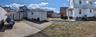 View of home's exterior featuring fence, an outdoor structure, a garage, and a storage unit