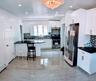 Kitchen with a peninsula, a chandelier, stainless steel appliances, a baseboard radiator, and decorative backsplash