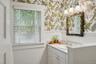 Bathroom with wainscoting, vanity, and wallpapered walls