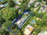 Aerial overview of property's location with nearby suburban area and property parcel outlined
