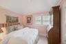 Bedroom with vaulted ceiling, wood ceiling, and light carpet