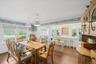 Dining room with wood finished floors, wallpapered walls, crown molding, and a chandelier