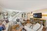 Living area featuring stairway, crown molding, and wood finished floors