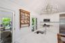 Kitchen featuring stainless steel appliances, a chandelier, healthy amount of natural light, vaulted ceiling, and tasteful backsplash