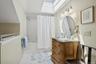 Master Bathroom with a skylight, tile patterned flooring, vanity, and shower / tub combo