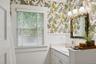 Bathroom with wainscoting, vanity, and wallpapered walls