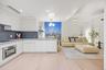 Kitchen with modern cabinets, stainless steel oven, white cabinets, and hanging light fixtures