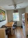 Wood-finish flooring with a ceiling fan light fixture and a window with blinds