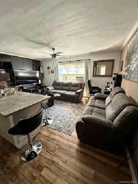 Wood-finish flooring throughout, complemented by an overhead ceiling fan