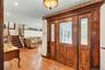 Elegant foyer showcasing ornate wood-paneled double doors with decorative glass inserts and detailed molding