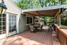 Spacious wood-finish deck featuring a partial overhead covering, offering an outdoor living area