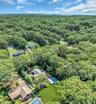 Sprawling wooded estate featuring multiple residences nestled throughout mature tree canopy