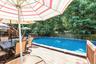 Expansive outdoor deck featuring an above-ground pool, wood fencing, and mature trees