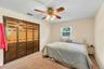 Bedroom with Built-in closet system with bi-fold doors, two-tone wood paneling, and decorative hardware