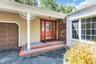 Welcoming front entrance featuring a red double-door entry with sidelights, brick detailing, and stepped brick walkway