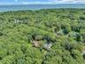 Wooded estate nestled on lush, mature grounds with expansive tree canopy
