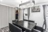 Dining area featuring a contemporary chandelier, wood-finish flooring, two windows, and a built-in closet with slatted panel doors