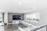 Spacious living area featuring wood-finish flooring, recessed lighting, and a prominent accent wall