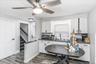 Modern kitchen area featuring white cabinetry, dark countertops, and wood-finish flooring