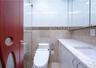Bathroom featuring a modern toilet, glass-enclosed shower, built-in vanity with integrated sink, and a mirrored medicine cabinet