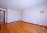 Bright room featuring wood-finish flooring with a decorative border, recessed lighting, and wall sconces