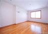 Spacious interior room featuring wood-finish flooring, recessed lighting, and decorative wall molding
