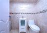 Modern bathroom featuring ceramic tile walls with decorative mosaic border stripe, a white vanity with integrated sink and storage drawers, contempora