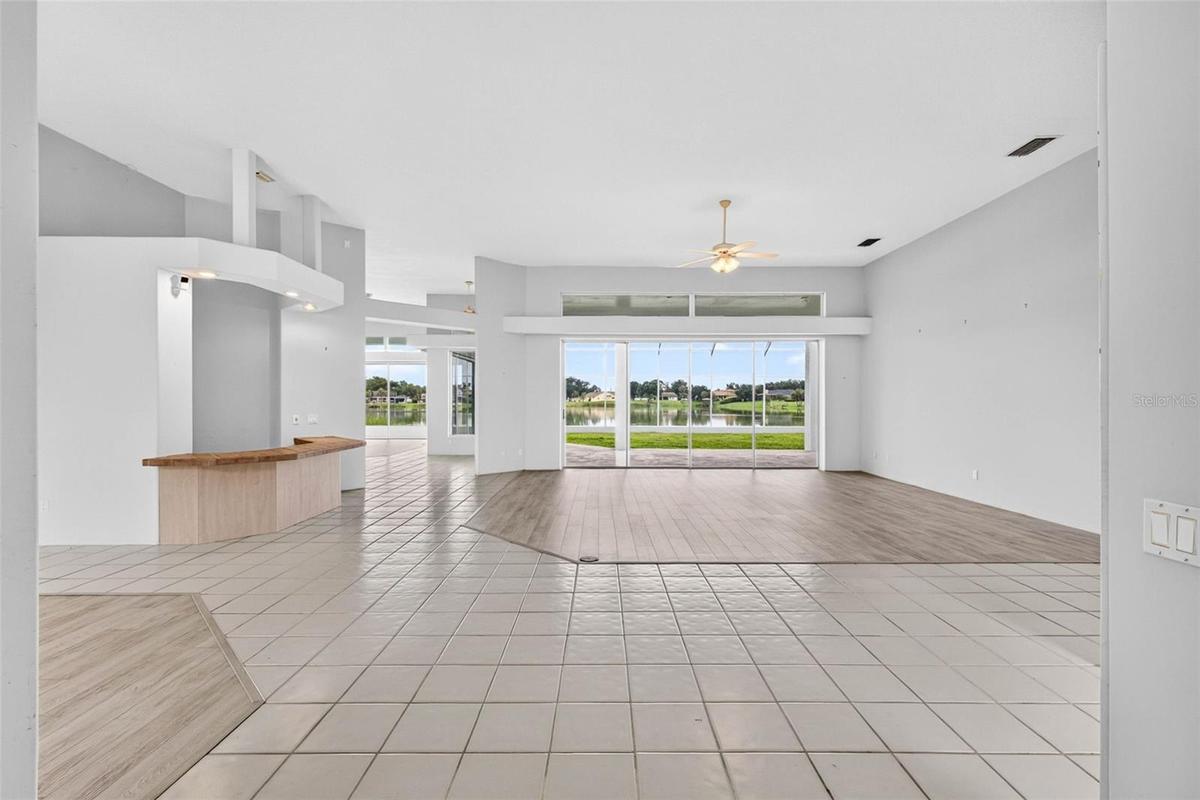From Entryway to Living Room, Bar Area, Breakfast Area with Aquarium Window and Family Room with Large Sliding Glass Doors to Covered Lanai off Living