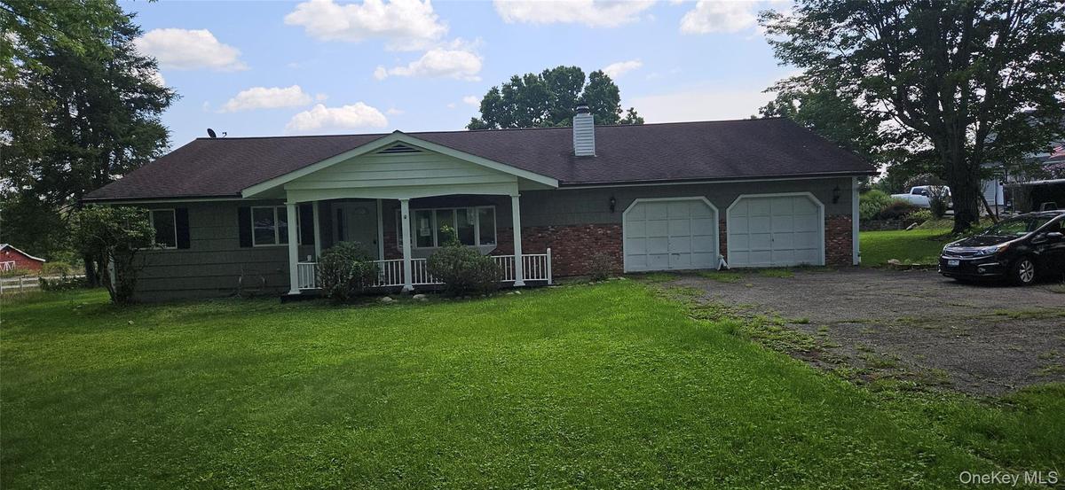 Ranch-style residence featuring a covered front porch, a two-car attached garage, and a brick facade accent