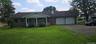 Ranch-style residence featuring a covered front porch, a two-car attached garage, and a brick facade accent