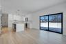 Bright dining space positioned beside kitchen and living room featuring wet bar and large glass sliders, offering great natural light and easy access 