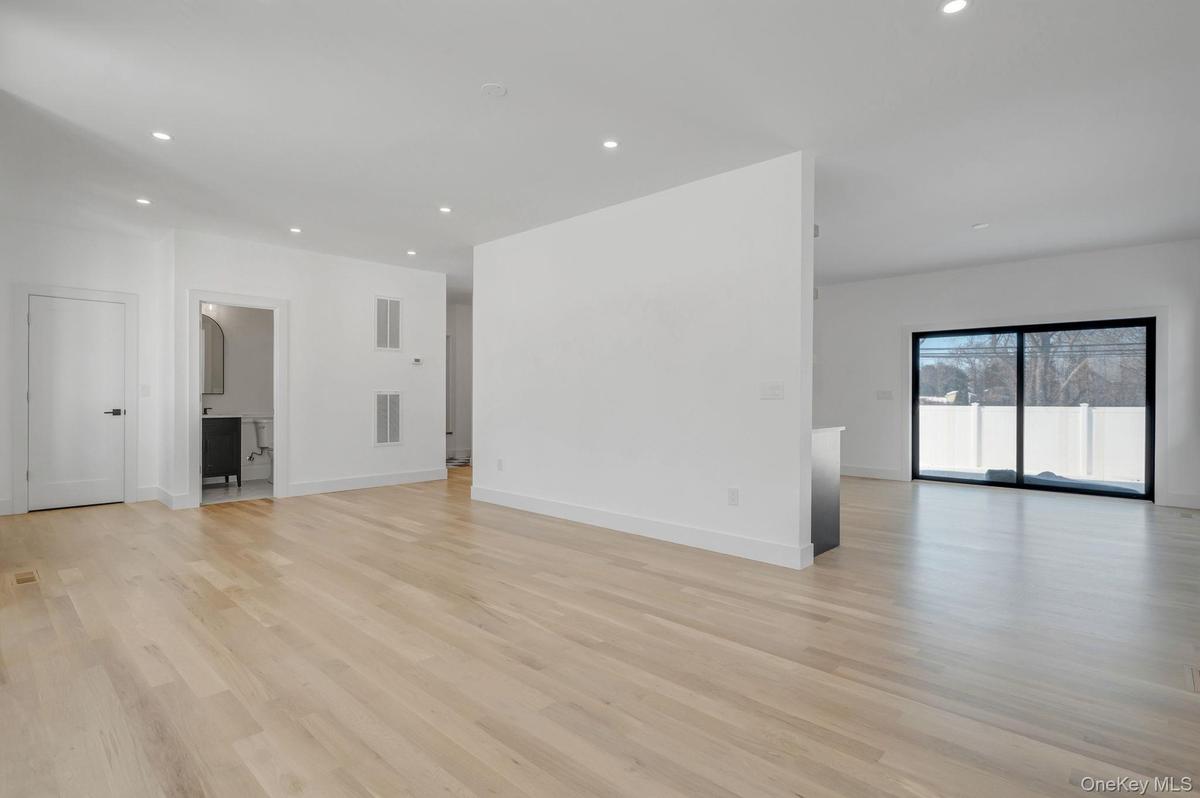 Spacious and open living area filled with natural sunlight from oversized windows, designed for both everyday comfort and entertaining.