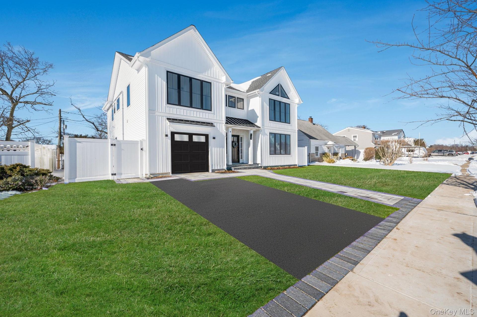 Modern Colonial exterior with board and batten style siding, black framed windows, and a covered entry that creates a strong, custom curb appeal.