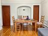 Dining room featuring hardwood / wood-style floors, a baseboard heating unit, and arched walkways