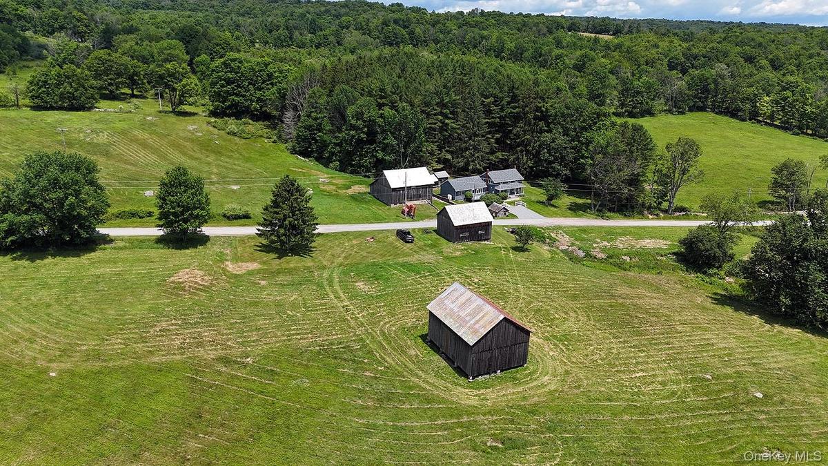 2 barns across the road from the home. 10.6 lush acres!