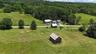 2 barns across the road from the home. 10.6 lush acres!