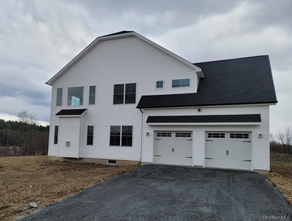 Side view featuring the two car garage, timeless Colonial styling enhanced by modern finished.