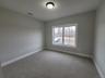 Spacious bedroom provides ample room for a full furniture arrangement offering comfort and versatility.