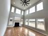 Dramatic great room featuring soaring ceilings and expansive windows that fill the living space with abundant natural light.