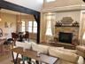 The main living area showcases impressive ceiling height, an open layout, and a fireplace centerpiece that adds warmth and character. Thoughtful archi