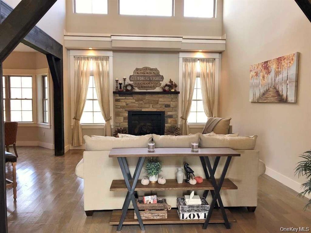 This expansive great room features soaring vaulted ceilings, gleaming red oak hardwood flooring, and abundant natural light.