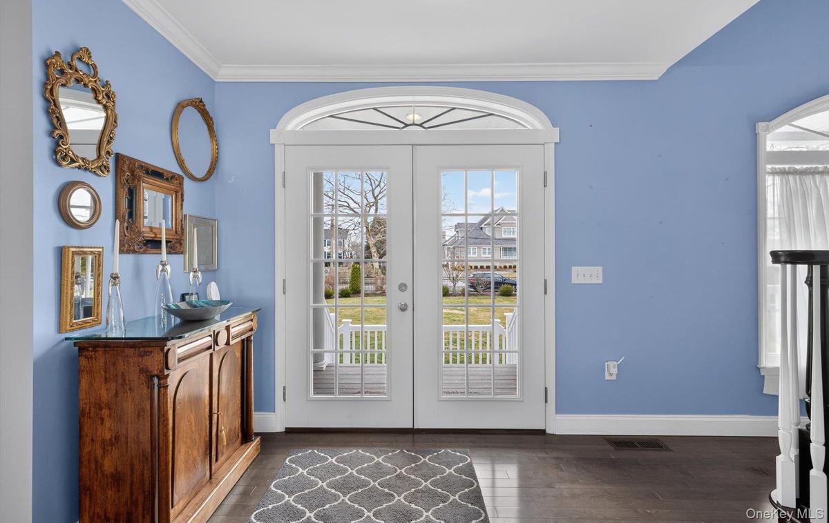 Doorway featuring ornamental molding, wood finished floors, and french doors