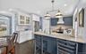 Kitchen with wine cooler, light stone counters, tasteful backsplash, glass insert cabinets, and stainless steel stove