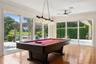 Game Room with view of the Pool and Lake.  Beautiful natural wood floor.  Sliding Energy effcient doors for the open air experience
