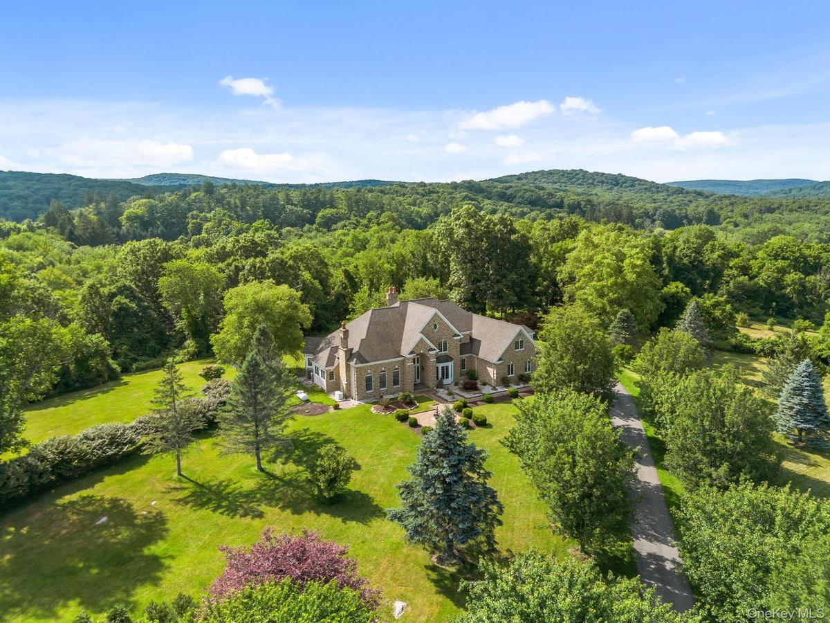 A private country estate awaits, beautifully sited on over 22 acres of rolling lawns, mature trees, and scenic beauty.