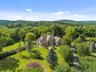 A private country estate awaits, beautifully sited on over 22 acres of rolling lawns, mature trees, and scenic beauty.