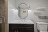 Bathroom vanity with a white marble countertop, undermount sink, and dark wood-finish cabinetry
