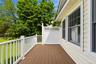 Exterior deck featuring composite wood-finish flooring, white railing, and white lattice privacy screen